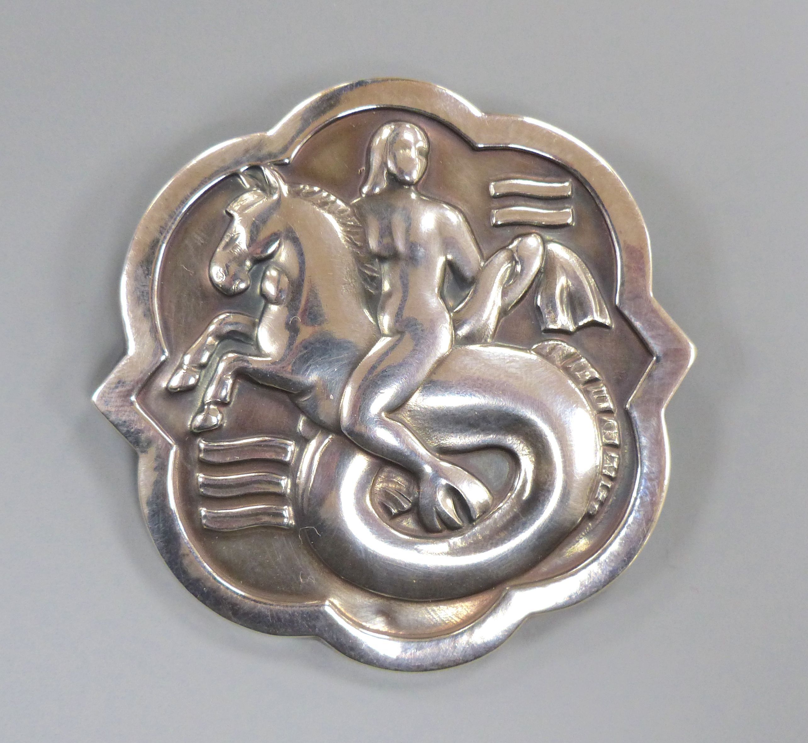 A George Jensen sterling shaped circular brooch, design no. 277 (Arno Malinowski?) depicting a mermaid on sea horse, 57mm.